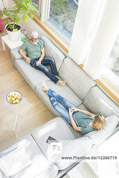 Ein reifes Paar entspannt sich zu Hause auf der Couch.