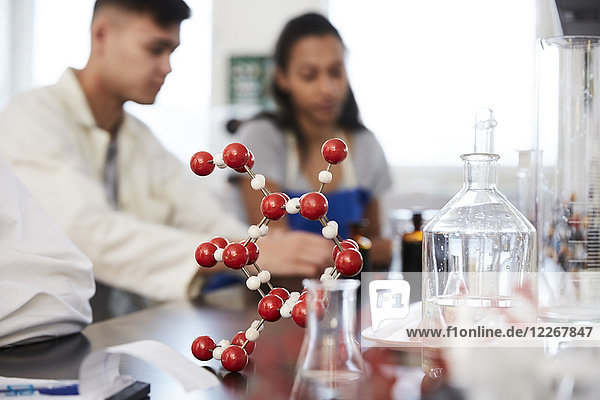 Molekülstruktur auf dem Tisch gegen junge Studenten im Chemielabor