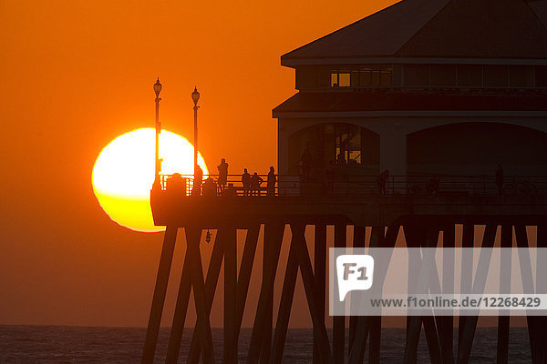 Sun setting behind pier at Huntington Beach  Orange County  California  USA