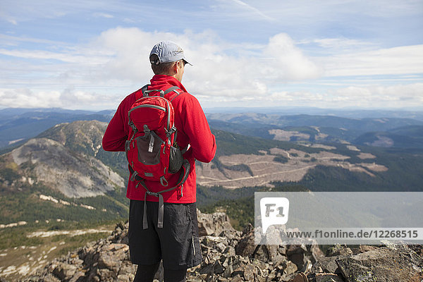 Rear view of man standing on summit of Jim Kelly Peak  Merritt  British Columbia  Canada