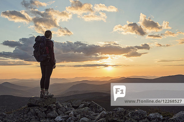 Female hiker admiring scenic sunset from top of Mount Abraham  Maine  USA