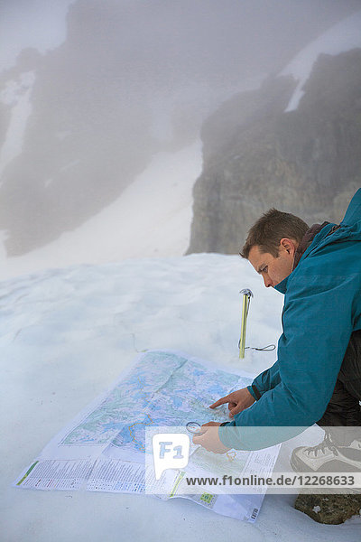 Mountaineer using map and compass to navigate after weather taking turn for worse  British Columbia  Canada
