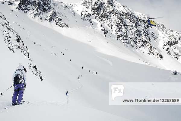 Eine Gruppe von Skifahrern wandert einen schneebedeckten Hang in den Pyrenäen hinauf  bevor sie sich auf einen Skiwettbewerb vorbereiten  Andorra
