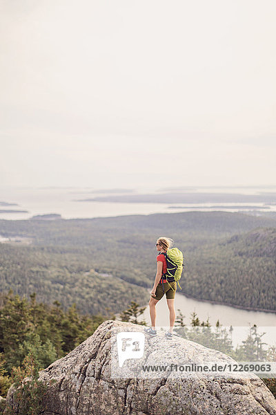 Weibliche Wanderin steht und betrachtet die Aussicht auf dem Gipfel des Pemetic Mountain  Acadia National Park  Maine  USA