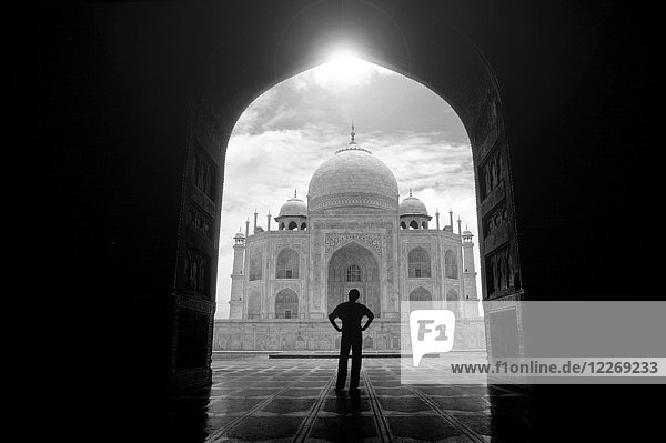 Rückansicht eines im Torbogen stehenden Mannes in der Nähe des Taj Mahal,  Agra,  Indien.