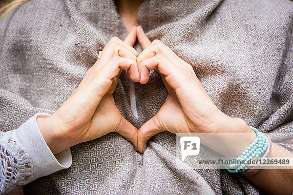 Young woman's hands making heart shape  cropped