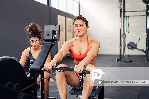 Women in gym using rowing machine