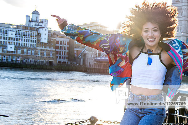Portrait of young woman outdoors  jumping for joy  London  England  UK