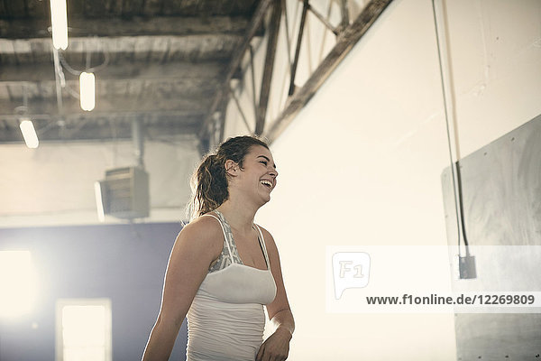 Porträt einer Frau im Fitnessstudio  die lächelnd wegschaut