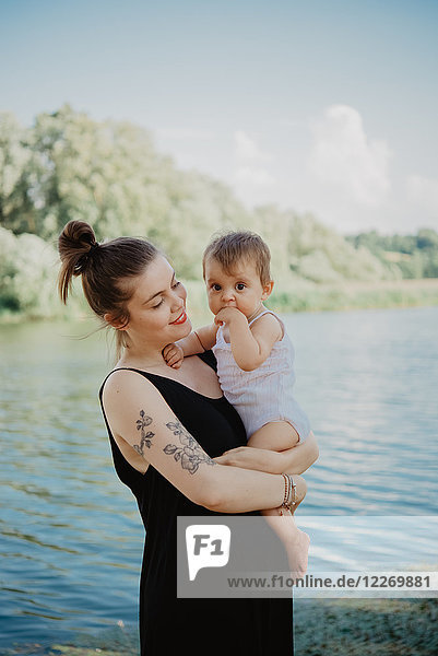 Woman with baby girl by lake  Arezzo  Tuscany  Italy
