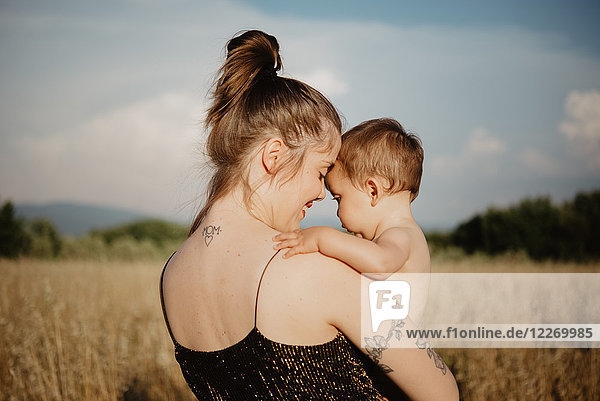 Woman with baby girl on golden grass field  Arezzo  Tuscany  Italy