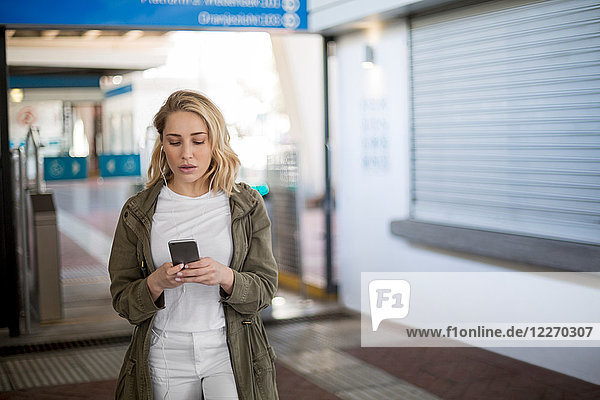 Frau benutzt Mobiltelefon an der Fahrkartenabsperrung  Kapstadt  Südafrika