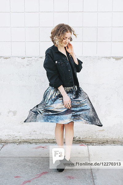 Woman in street twirling metallic skirt