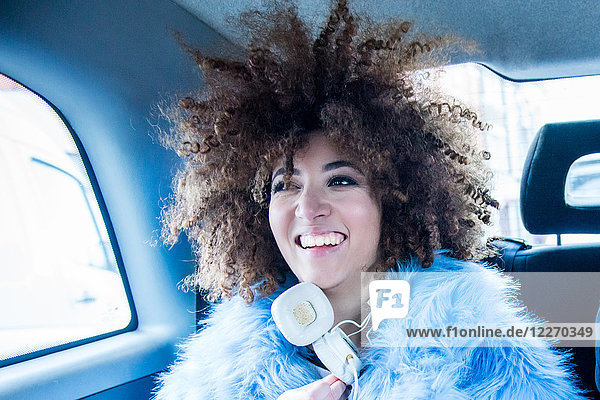 Portrait of young woman in back of taxi  smiling
