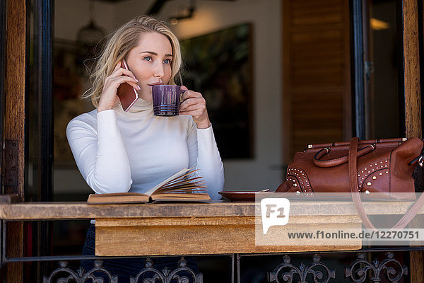 Woman on mobile phone at cafe Cape Town South Africa