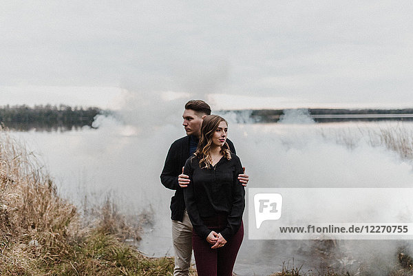 Young couple by smoke cloud looking away  Ottawa  Canada