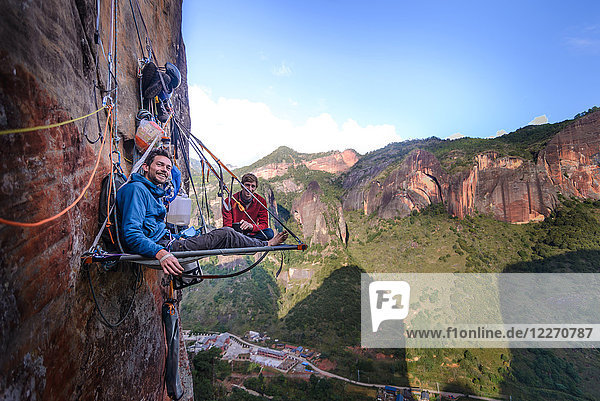 Portrait of two rock climbers on portaledge  Liming  Yunnan Province  China