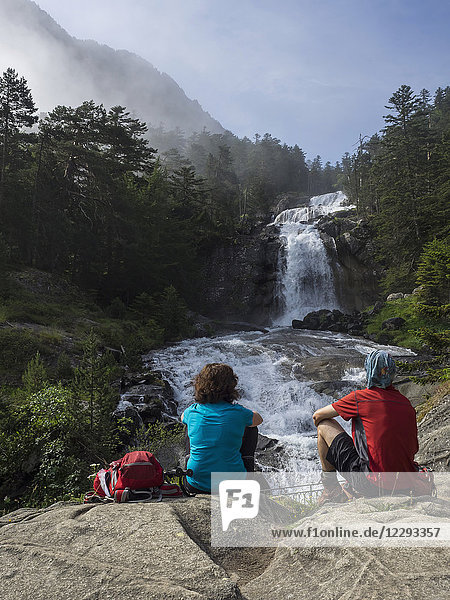 Wanderer bewundern die malerische Aussicht auf einen Wasserfall im Fluss Gave De Gaube  Frankreich