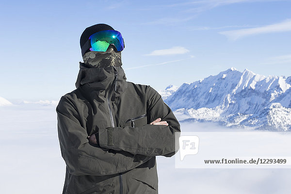 Porträt eines Mannes mit bedecktem Gesicht und schneebedeckten Bergen im Hintergrund