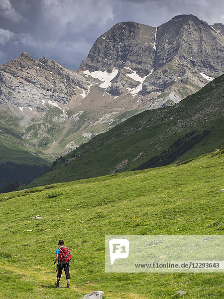 Woman hiking in the High Pyrenees descending Oulettes d'Ossoue towards Gavarnie  France