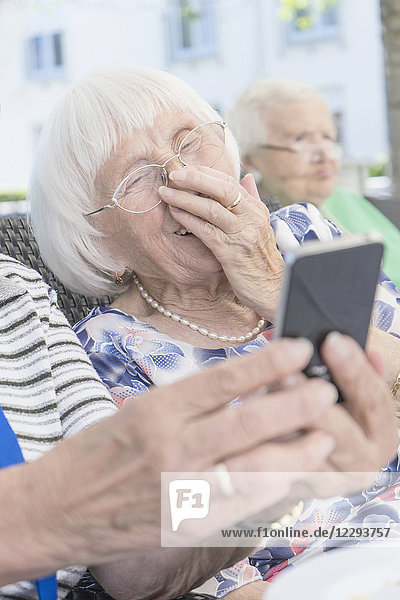 Senior woman looking at smartphone and laughing