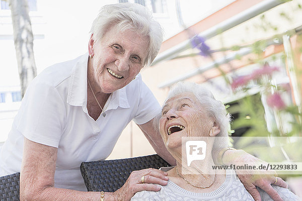 Zwei lachende Seniorinnen im Pflegeheim