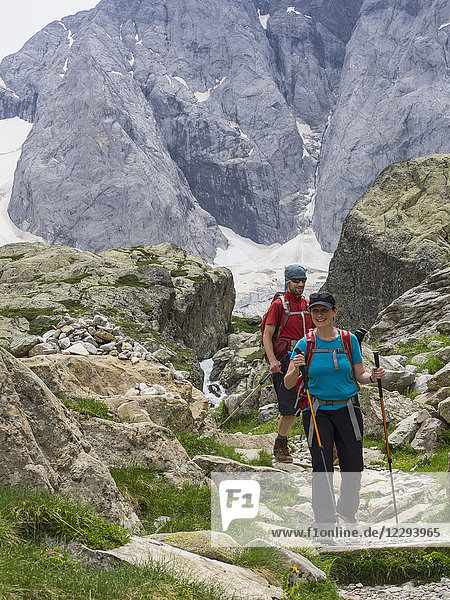 Man and woman hiking in the High Pyrenees in front of mount Vignemale  Cauterets  France