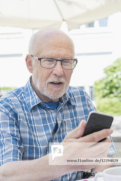 Älterer Mann benutzt ein Smartphone