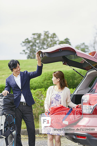 Japanisches Paar bereitet sich auf das Golfspiel vor