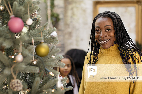 Portrait smiling  confident woman at Christmas tree