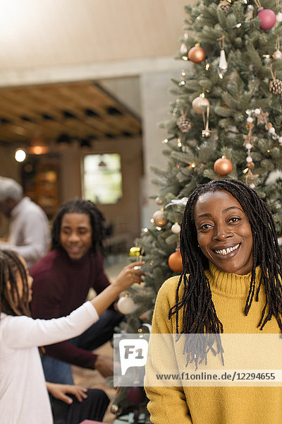 Portrait smiling mother decorating Christmas tree with children