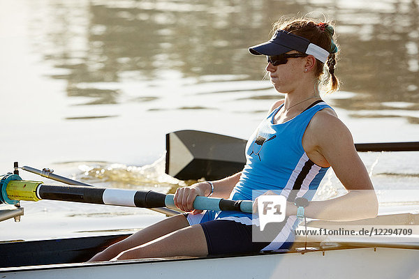 Determined female rower rowing scull