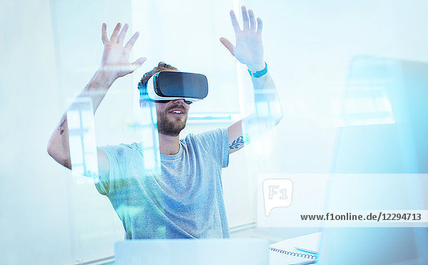 Männlicher Programmierer testet Virtual-Reality-Simulator-Brille im Büro