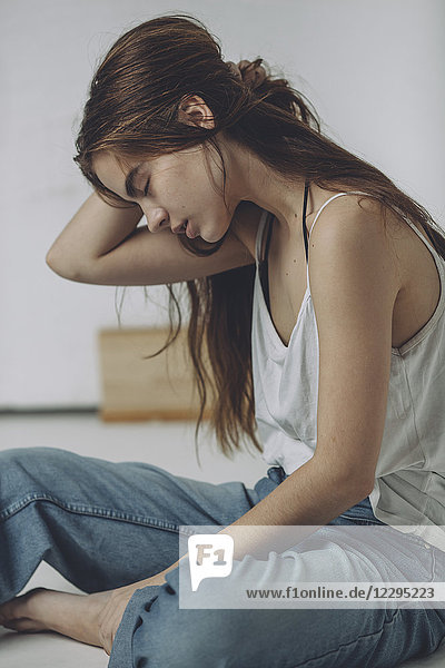 Volle Länge des Teenagermädchens auf dem Boden sitzend