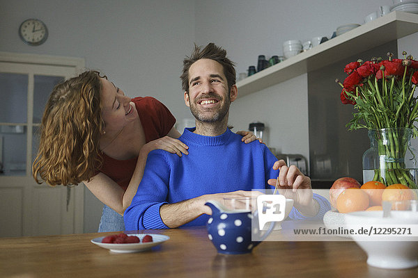 Fröhliches mittleres erwachsenes Paar am Tisch mit Frühstück im Zimmer
