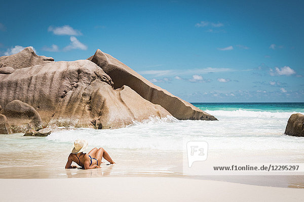 Rückansicht der mittleren erwachsenen Frau im Bikini am Strand gegen den blauen Himmel  Seychellen