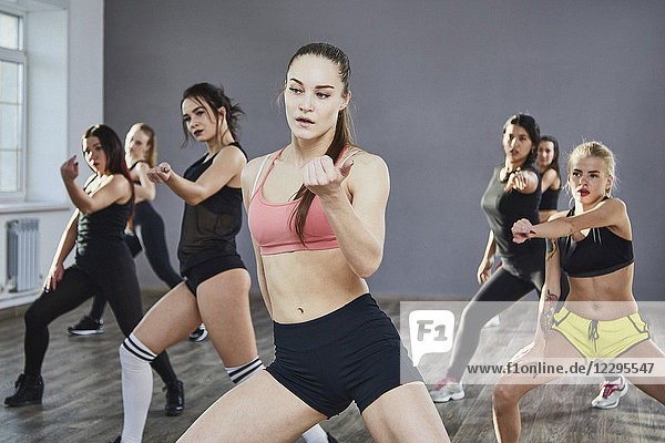 Selbstbewusste Tänzerinnen und Tänzer in Sportbekleidung üben im Studio