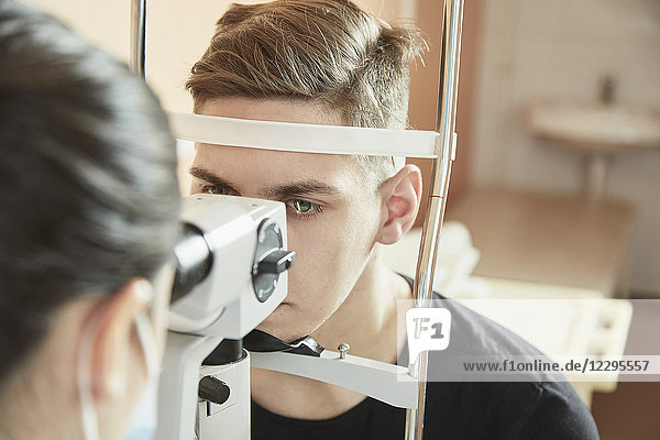 Augenarzt bei der Untersuchung des männlichen Patienten während des Sehtests im Krankenhaus