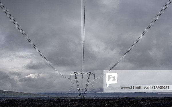 Electricity pylon against cloudy sky  Highlands  Iceland