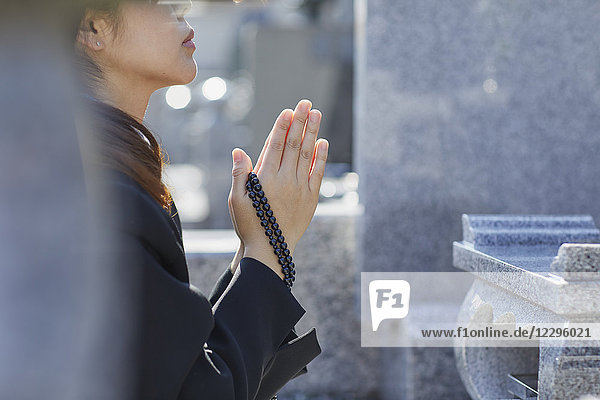 Japanische Frau auf einem Friedhof
