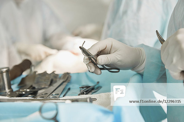 Mittelteil des Chirurgen mit einer chirurgischen Schere während der Operation im Krankenhaus
