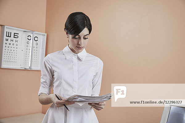 Krankenschwester beim Lesen von Papieren im Krankenhaus