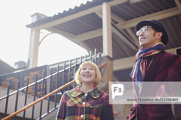 Low angle view of smiling couple standing against house