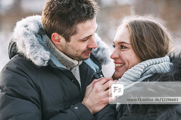 Lächelnde junge Frau hält Händchen mit Mann