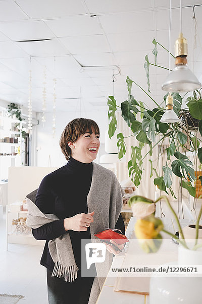 Cheerful female customer standing in upholstery shop