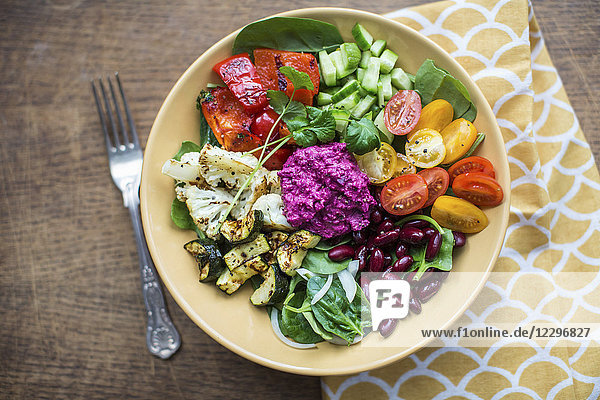 Schüssel mit Salat  gebratenem Gemüse  Bohnen und Rote-Bete-Hummus