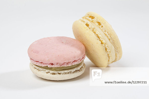 Zwei Macarons vor weissem Hintergrund (Nahaufnahme)