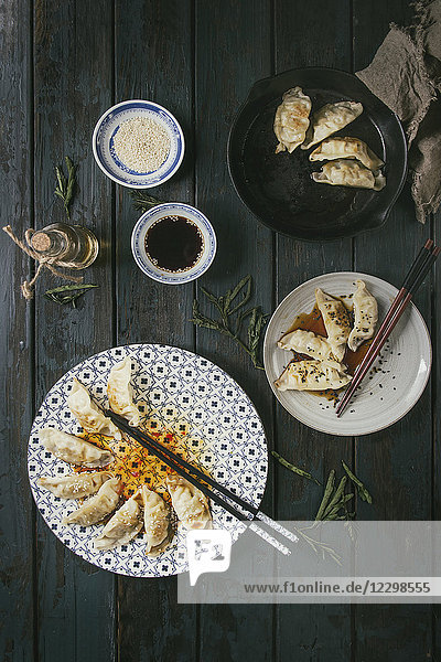 Asiatische Teigtaschen Gyozas Kartoffelstäbchen auf weißem  blauem Keramikteller