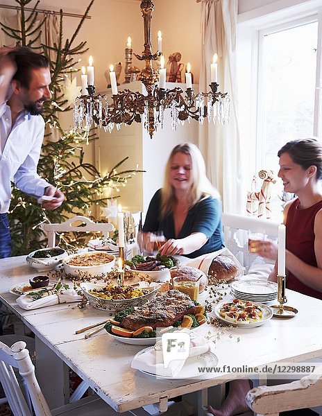 Eine Familie sitzt um einen für das Weihnachtsessen gedeckten Tisch