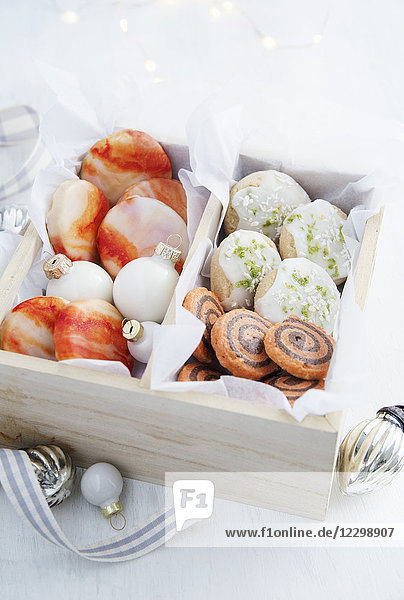Orangenkekse mit marmorierter Orangenglasur  Orangen- und Schokoladen-Pinwheel-Kekse und Limetten- und Kokosnuss-Mürbegebäck  alle in einer hölzernen Geschenkbox mit Seidenpapier